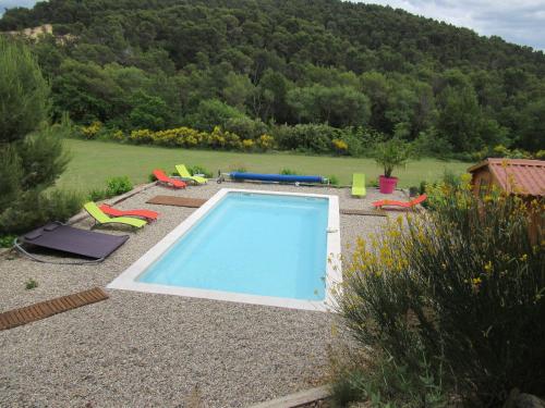 - une piscine dans une cour avec une colline dans l'établissement Résidence de gîtes La Sidoine du Mont-Ventoux, à Crillon-le-Brave