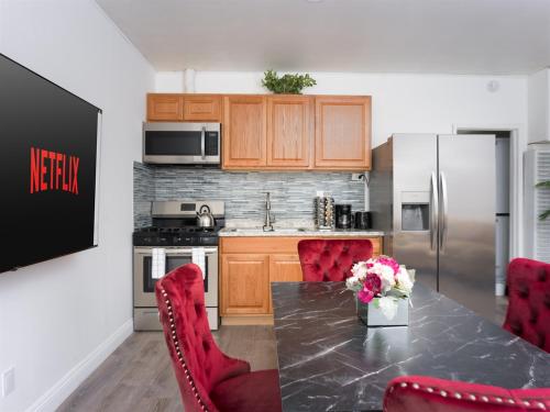 a kitchen with a table with red chairs and a refrigerator at Private 1BR w Yard & King Bed Simi Valley in Simi Valley