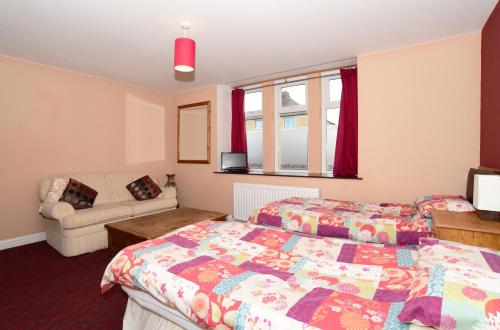 a bedroom with two beds and a couch at St. Cyrus Village Inn in Saint Cyrus