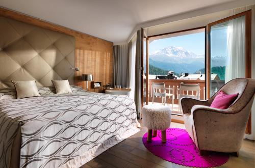 a bedroom with a bed and a chair and a balcony at Giardino Mountain in St. Moritz