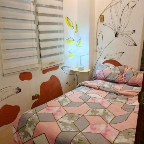 a bedroom with a bed with a flower design on the wall at M3 Haven Masbate in Masbate