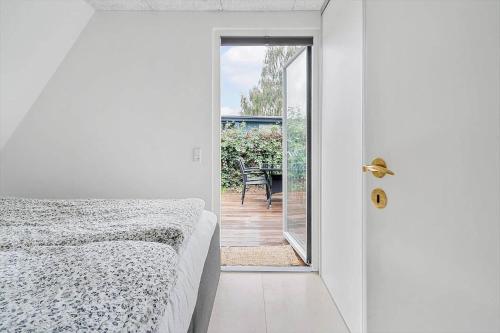 a bedroom with a bed and a door to a patio at 40160-Juelsminde-Hasselvej-8 in Juelsminde