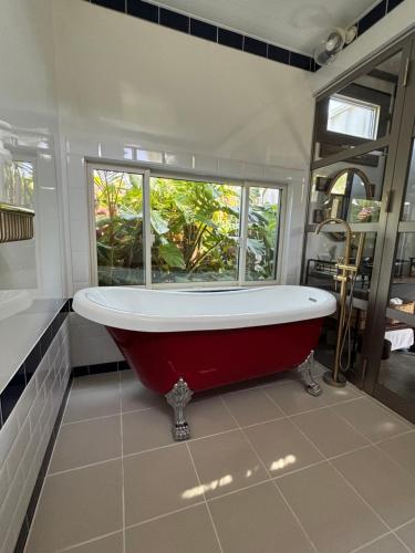 a red bath tub in a bathroom with a window at Vacation Village Pet-friendly & SUPYAK in Nakijin