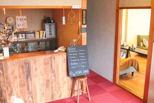 a restaurant counter with a chalkboard sign in front of it at ゲストハウスkaminn in Yoshino