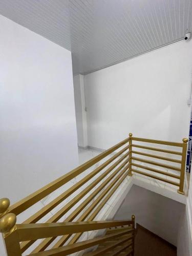 a wooden bench in a room with a white wall at Mubarak Hostel Syari'ah in Bukittinggi