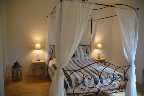 um quarto com uma cama de dossel e cortinas brancas em Chiemsee Beachhouse Apartment em Bernau am Chiemsee