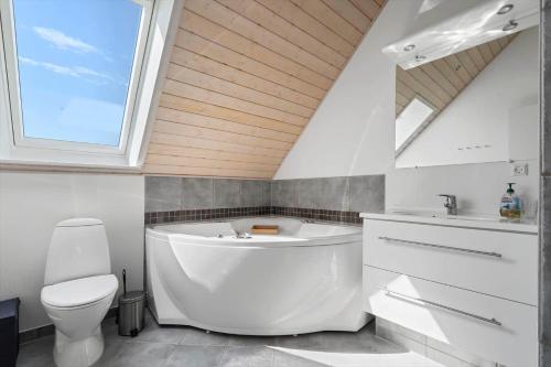 a bathroom with a white tub and a toilet at 40172-Juelsminde-Strandengen-30 in Juelsminde