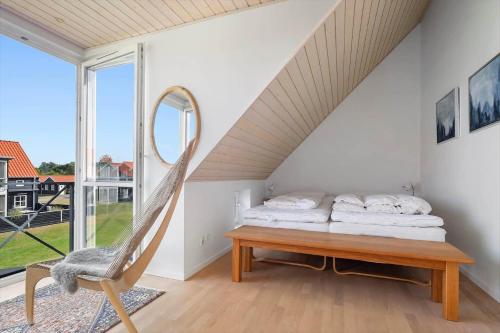 a bedroom with a bed and a chair and a mirror at 40172-Juelsminde-Strandengen-30 in Juelsminde