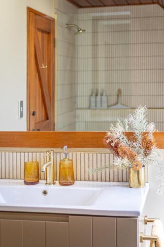 a bathroom sink with a mirror and a sink at Edwoods Boutique Bed & Breakfast in Oamaru