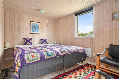a bedroom with a bed and a window and a chair at 40607-Juelsminde-Pilevaenget-16 in Juelsminde