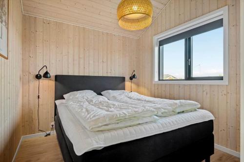 a bedroom with a bed and a window and a lamp at 30427-Saksild-Strandvaenget-31 in Saksild
