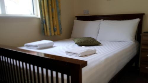 1 cama con 2 toallas y 2 almohadas en Hazelbrook House B&B, en Dublín
