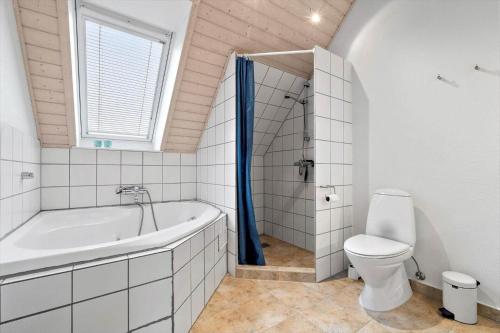 a white bathroom with a tub and a toilet at 40173-juelsminde-Strandengen-46 in Juelsminde