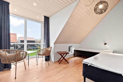 a bedroom with a bed and a table and chairs at 40173-juelsminde-Strandengen-46 in Juelsminde