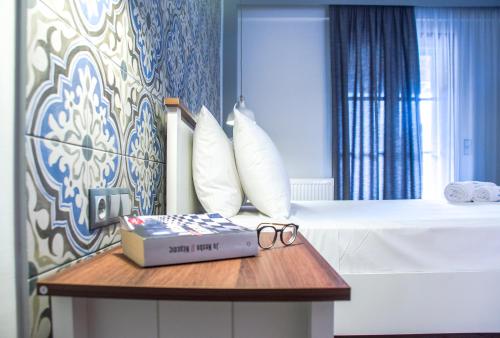 a room with a bed with a book and glasses on a table at Aparthotel Ano in Acharavi