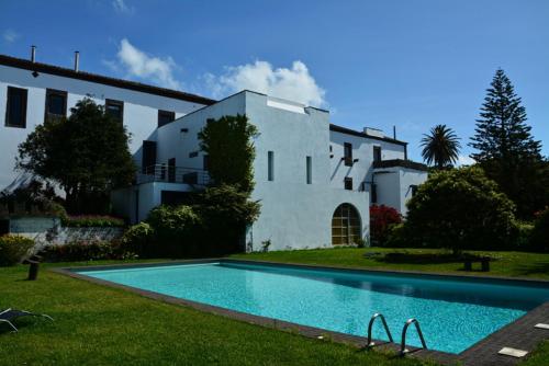 a house with a swimming pool in front of a house at Convento de São Francisco in Vila Franca do Campo