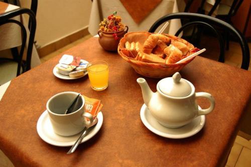 un tavolo con una tazza di tè e un cesto di cibo di Hotel del Paseo a Mar del Plata