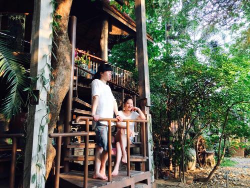 a man and a woman standing on a staircase of a house at BaanBooLoo Village in Chiang Mai