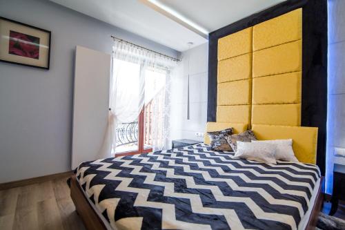 a bedroom with a large bed with a yellow headboard at Apartament Tatry One in Zakopane