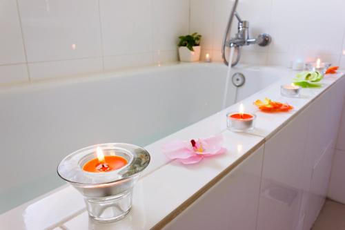 a white bath tub with candles and flowers on a counter at Shamrock Beach Villas 15 Seaview in George Town