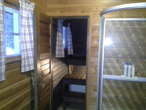 een houten hut met een bank en een raam bij Vipati Cottage in Ylitornio