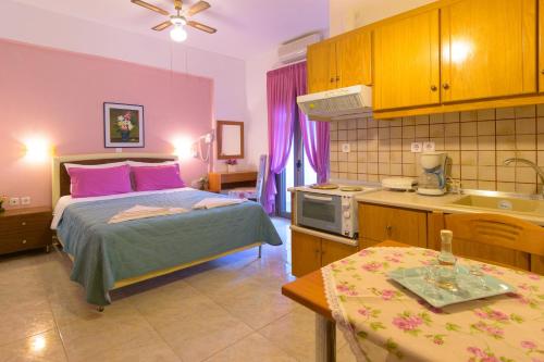 a bedroom with a bed and a kitchen with a sink at Villa Minoas Apartments in Istron