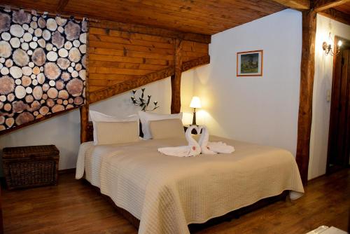 a bedroom with a bed in a room with wooden ceilings at Momini Dvori Boutique Guest House in Bansko