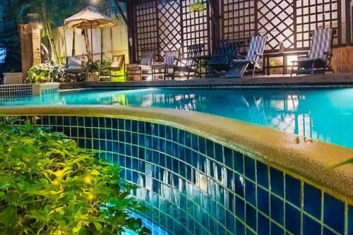 a swimming pool in a resort with chairs at Silom Serene A Boutique Hotel in Bangkok
