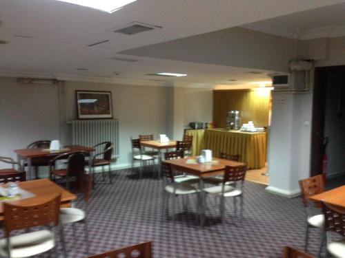 uma sala de jantar com mesas e cadeiras de madeira em Hotel Atasayan em Gebze