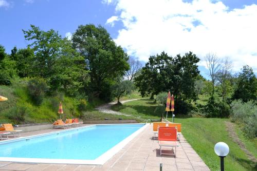 a swimming pool with orange chairs at Agriturismo Marano in Mengara