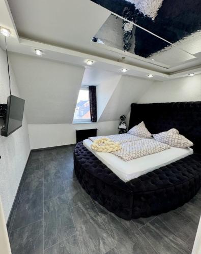 a bedroom with a large black bed in a room at Phöenixpalace Whirlpool & Infarotsauna in Dortmund