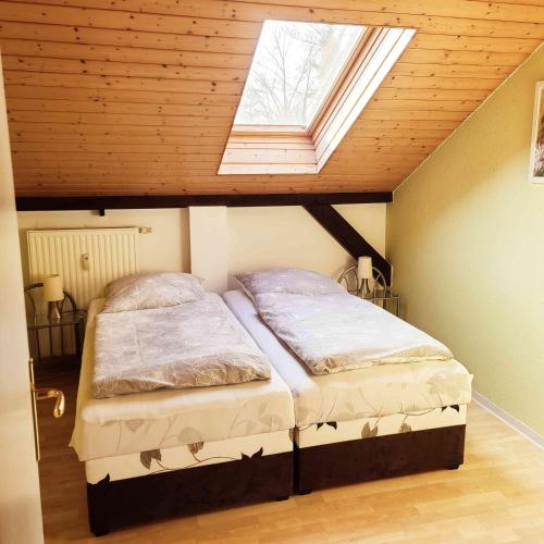 a bedroom with two beds in a room with a skylight at FeWo Hoffmann DG - Ihr Domizil für Arbeit oder Kurzurlaub in Böhlen
