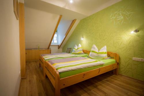 a small bedroom with a bed with green walls at Ferienwohnung "Beim Nachtwächter" in Görlitz