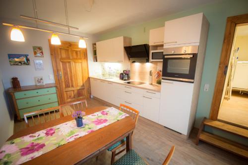 a kitchen with a dining table and a kitchen with a refrigerator at Ferienwohnung "Beim Nachtwächter" in Görlitz