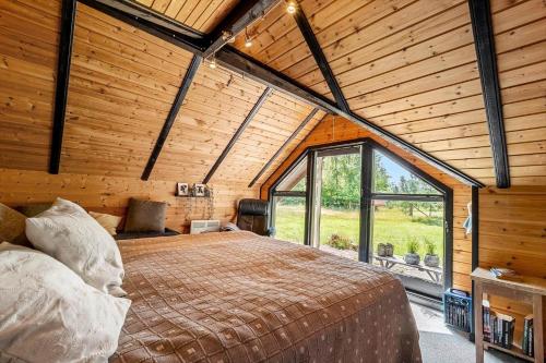 a bedroom with a large bed in a room with wooden walls at M368-Rodby-Spurvevaenget-11 in Rødby