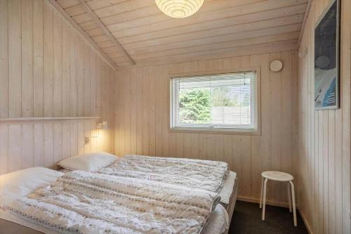 a bedroom with a bed in a room with a window at M369-Vaeggerlose-Mimosevej-19 in Bøtø By
