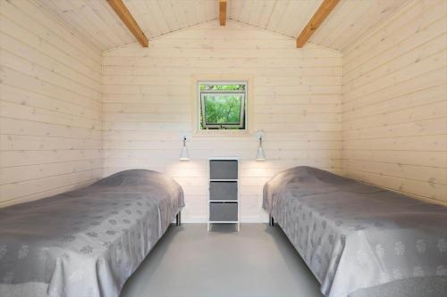 two beds in a small room with a window at 1608-Melby-Elna-Lassensvej-10 in Melby