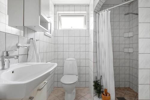 a white bathroom with a toilet and a sink at 1484-N-Gilleleje-Markvaenget-11 in Gilleleje