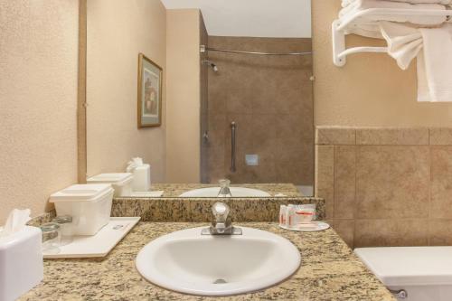 a bathroom with a sink and a toilet and a shower at Ramada by Wyndham Fresno North in Fresno