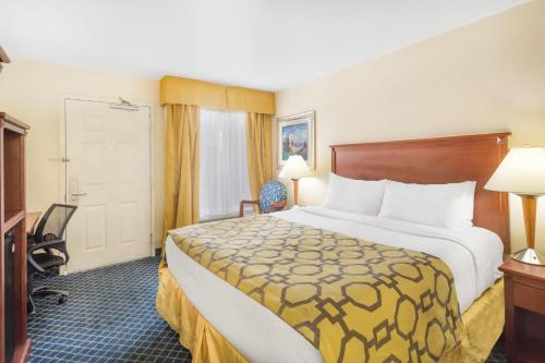 a hotel room with a large bed and a desk at Baymont by Wyndham Flagstaff in Flagstaff