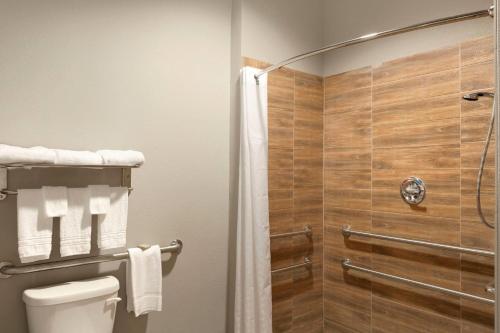a bathroom with a shower and a toilet at Super 8 by Wyndham Carrizo Springs in Carrizo Springs