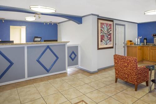 a waiting room with a counter and a chair at Travelodge by Wyndham Fort Myers North in North Fort Myers