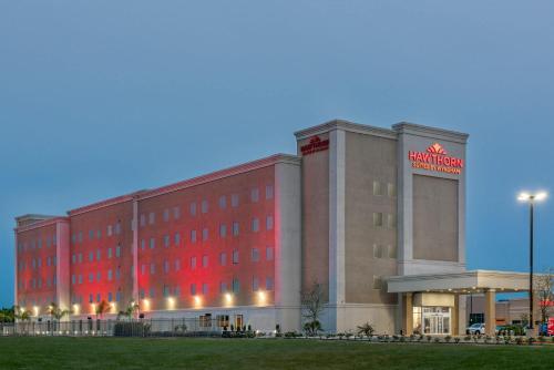 a hotel building with a red sign on it at Hawthorn Extended Stay by Wyndham McAllen in McAllen