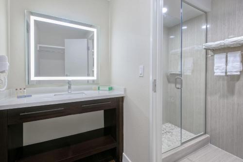 a bathroom with a sink and a shower with a mirror at Hawthorn Extended Stay by Wyndham McAllen in McAllen