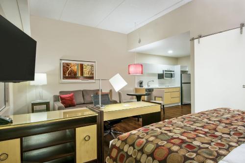 a room with a bed and a desk and a couch at Hawthorn Extended Stay by Wyndham McAllen in McAllen