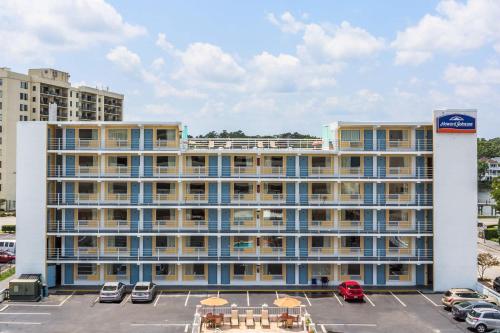 a large building with cars parked in a parking lot at Howard Johnson by Wyndham Virginia Beach At The Beach in Virginia Beach