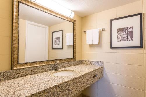 a bathroom with a sink and a mirror at Howard Johnson by Wyndham Virginia Beach At The Beach in Virginia Beach
