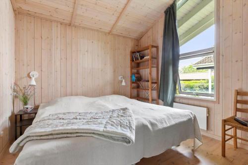 a bedroom with a white bed and a window at 1497-N-Gilleleje-Parcelvej-3 in Gilleleje