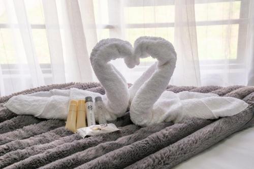 a bed with two swans shaped towels on it at Unit 4 at Homely Escapes in Phalaborwa