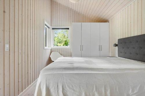 a bedroom with a white bed and a window at 1576-Liseleje-Korntoften-7 in Liseleje